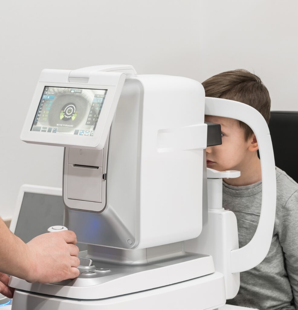 Control de miopía con biómetro Niño realizando un control de miopía con biómetro